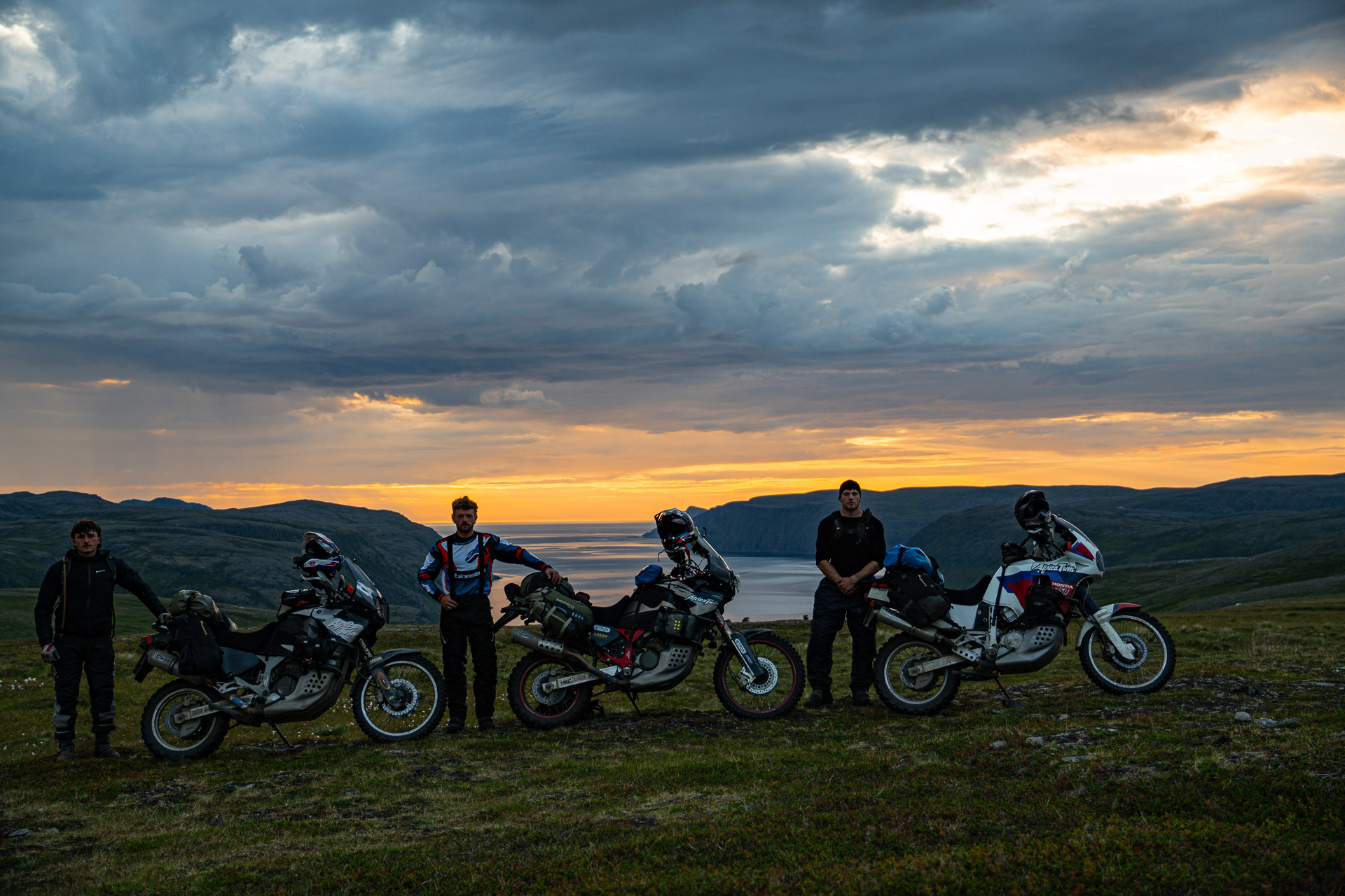 Three riders on Honda XRV750 adventure motorcycles navigating a gravel road on the Swedish Trans Euro Trail.